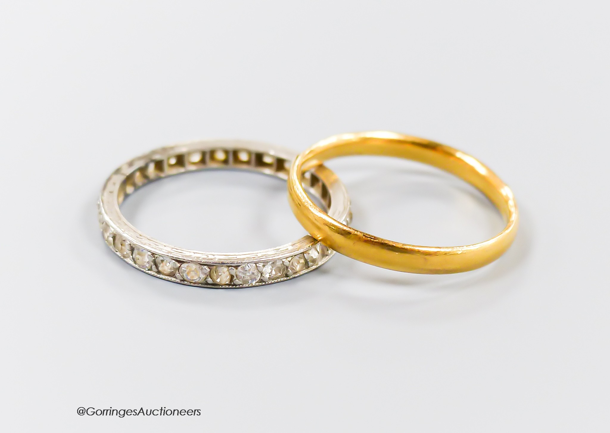 A 22ct gold wedding band, size M, 2.3 grams and a white metal and diamond set full eternity ring, size N, gross 2.5 grams.